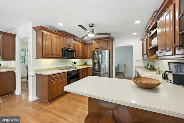 8201 Briar Creek Dr, Annandale, VA 22003 - kitchen featuring black appliances, a ceiling fan, a peninsula, light countertops, and light wood-style floors