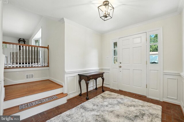 8201 Briar Creek Dr, Annandale, VA 22003 - entrance foyer with brick flooring, a chandelier, a wainscoted wall, and crown molding