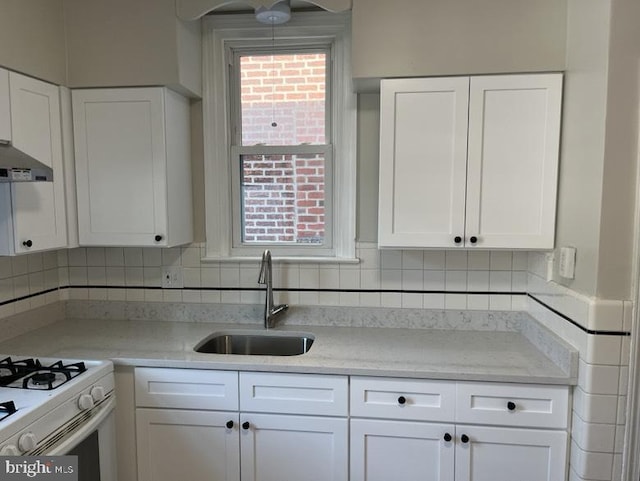 3019 Magee Ave, Philadelphia, PA 19149 - kitchen with white cabinetry, exhaust hood, backsplash, gas range gas stove, and healthy amount of natural light