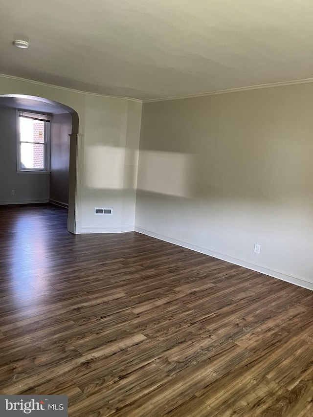 3019 Magee Ave, Philadelphia, PA 19149 - empty room with crown molding, arched walkways, dark wood finished floors, and a smoke detector
