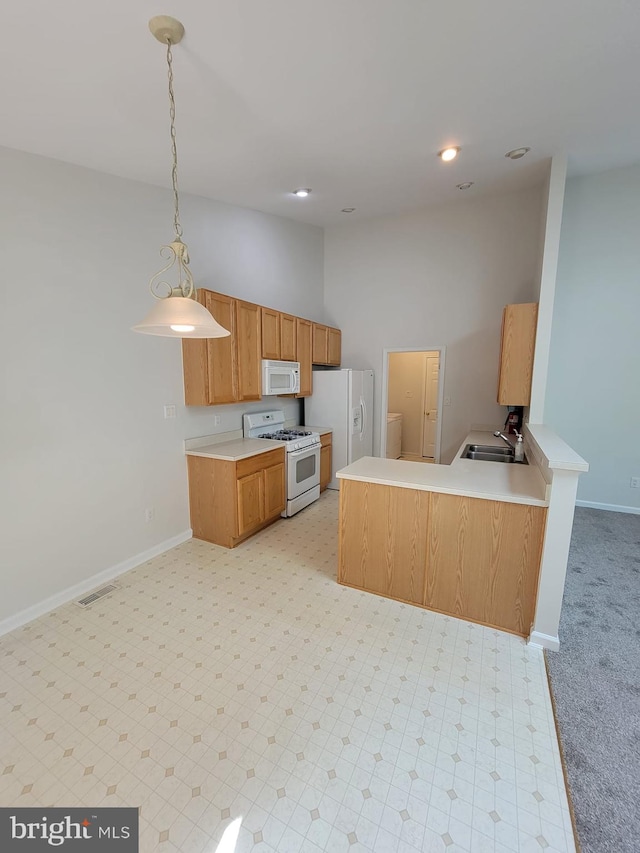 29 Hearthstone Blvd, Pemberton, NJ 08068 - kitchen with white appliances, light countertops, hanging light fixtures, a peninsula, and brown cabinets