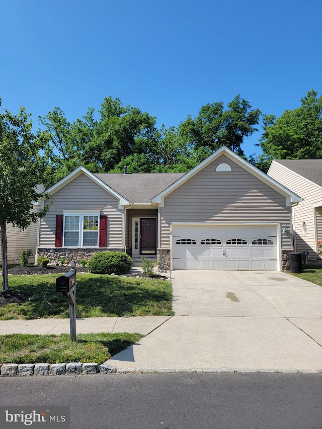 29 Hearthstone Blvd, Pemberton, NJ 08068 - ranch-style house with an attached garage, stone siding, concrete driveway, and a front lawn