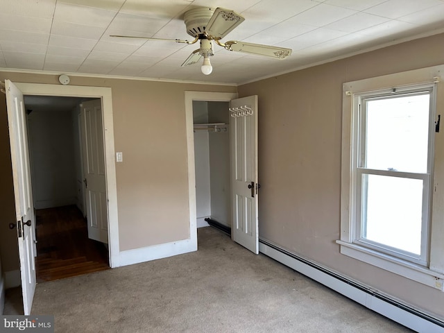 135-137 S 6th St, Shamokin, PA 17872 - unfurnished bedroom with baseboard heating, crown molding, carpet, a closet, and ceiling fan