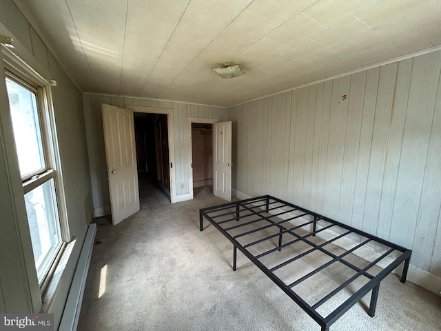 135-137 S 6th St, Shamokin, PA 17872 - unfurnished bedroom with a baseboard heating unit, light colored carpet, wooden walls, and a closet