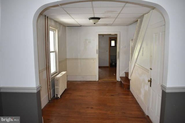 135-137 S 6th St, Shamokin, PA 17872 - hall with radiator, a drop ceiling, dark wood-type flooring, stairs, and arched walkways