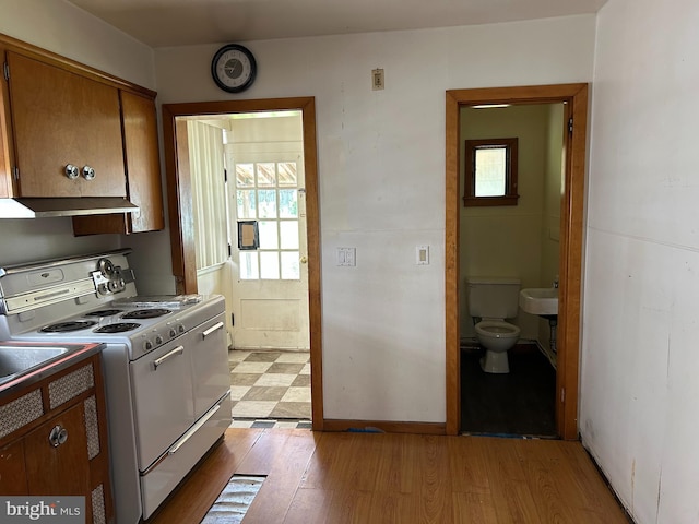 135-137 S 6th St, Shamokin, PA 17872 - kitchen with white electric range oven, healthy amount of natural light, brown cabinets, and extractor fan