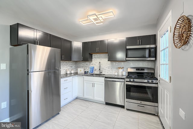 267 Southeastern Ter, Baltimore, MD 21221 - kitchen with appliances with stainless steel finishes, dark stone countertops, decorative backsplash, and light tile patterned floors