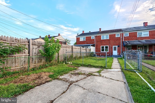 267 Southeastern Ter, Baltimore, MD 21221 - back of house with brick siding, a gate, and a chimney