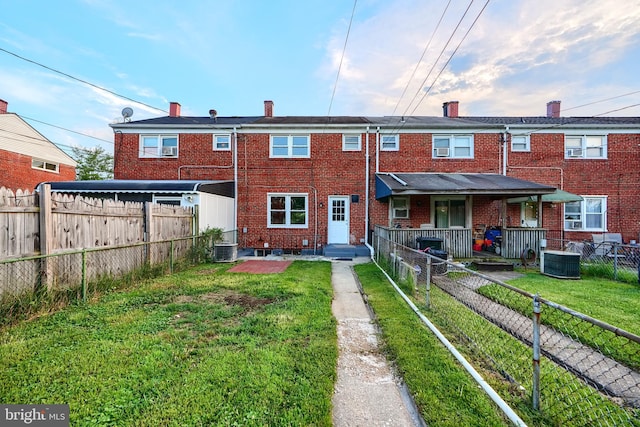267 Southeastern Ter, Baltimore, MD 21221 - back of house featuring brick siding, a fenced backyard, and a chimney