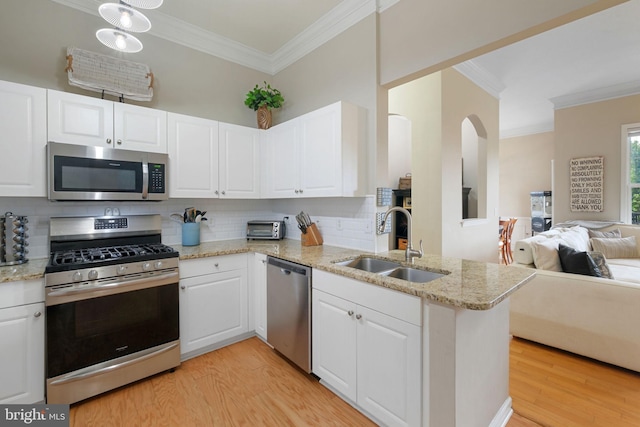 7 Booth St Unit 402, Gaithersburg, MD 20878 - kitchen with appliances with stainless steel finishes, open floor plan, ornamental molding, light wood-type flooring, and tasteful backsplash