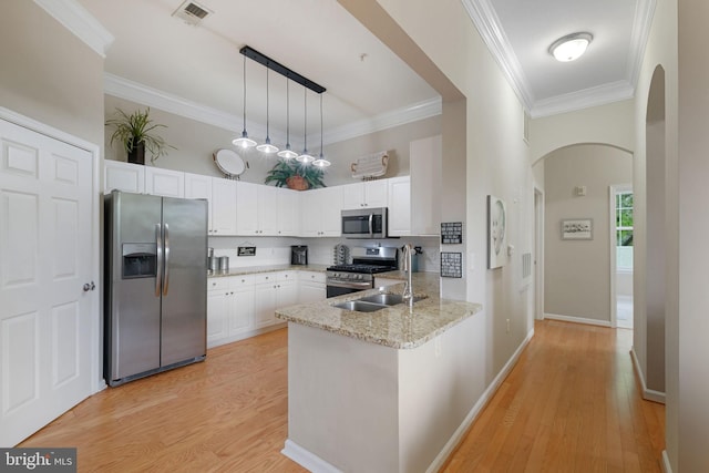 7 Booth St Unit 402, Gaithersburg, MD 20878 - kitchen featuring appliances with stainless steel finishes, arched walkways, a peninsula, white cabinetry, and light stone counters