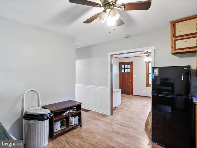 679 Winchester Grade Rd, Berkeley Springs, WV 25411 - kitchen featuring freestanding refrigerator, ceiling fan, light wood-type flooring, and a wainscoted wall