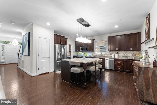 6006 New Hampshire Ave NE, Washington, DC 20011 - kitchen with stainless steel appliances, dark brown cabinetry, a kitchen island, dark wood finished floors, and recessed lighting