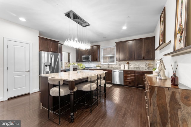 6006 New Hampshire Ave NE, Washington, DC 20011 - kitchen featuring appliances with stainless steel finishes, dark brown cabinetry, tasteful backsplash, light stone countertops, and recessed lighting