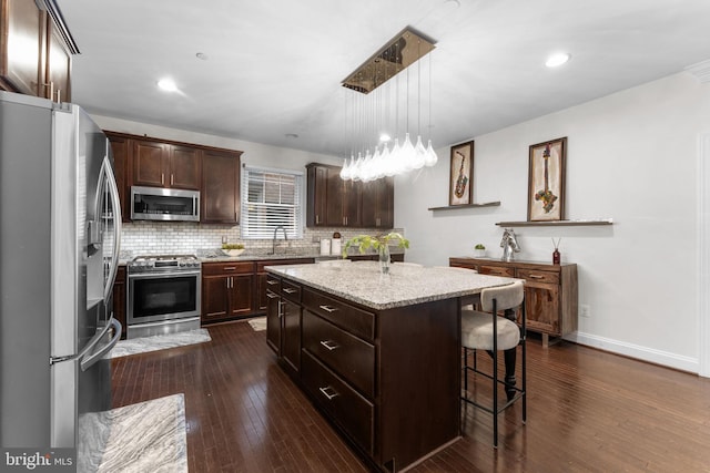6006 New Hampshire Ave NE, Washington, DC 20011 - kitchen featuring appliances with stainless steel finishes, a kitchen island, dark wood finished floors, dark brown cabinetry, and recessed lighting