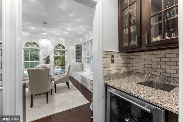 6006 New Hampshire Ave NE, Washington, DC 20011 - indoor dry bar featuring beverage cooler, dark wood-style flooring, backsplash, ornamental molding, and decorative light fixtures