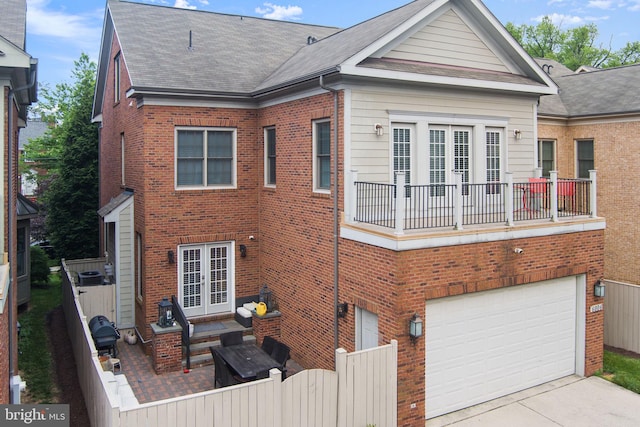 6006 New Hampshire Ave NE, Washington, DC 20011 - back of property with brick siding, an attached garage, french doors, concrete driveway, and a shingled roof