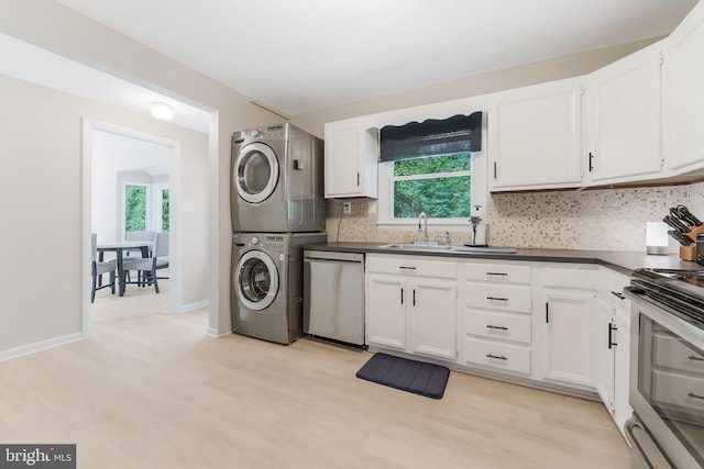 7920 Old Falls Rd, Mclean, VA 22102 - laundry area featuring estacked washer and dryer, healthy amount of natural light, and light wood-style flooring