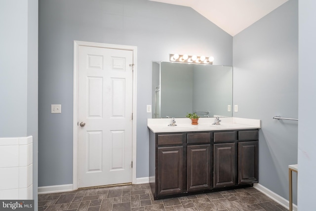 715 Dairy Dr, Middletown, DE 19709 - bathroom featuring double vanity, lofted ceiling, and stone finish floors