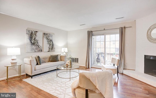 927 S Rolfe St Unit 2, Arlington, VA 22204 - living area featuring a brick fireplace, wood finished floors, and crown molding