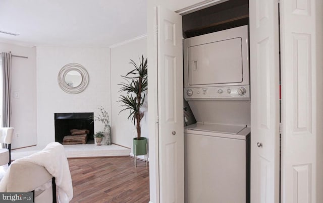 927 S Rolfe St Unit 2, Arlington, VA 22204 - washroom featuring stacked washing machine and dryer, ornamental molding, wood finished floors, and a fireplace
