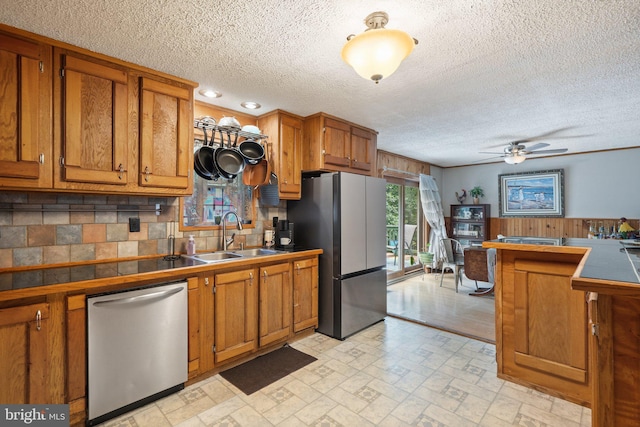 590 Vaught Dr, Front Royal, VA 22630 - kitchen with appliances with stainless steel finishes, brown cabinetry, a ceiling fan, tasteful backsplash, and a textured ceiling