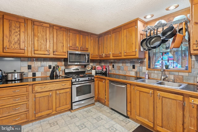590 Vaught Dr, Front Royal, VA 22630 - kitchen featuring appliances with stainless steel finishes, brown cabinets, a textured ceiling, and decorative backsplash