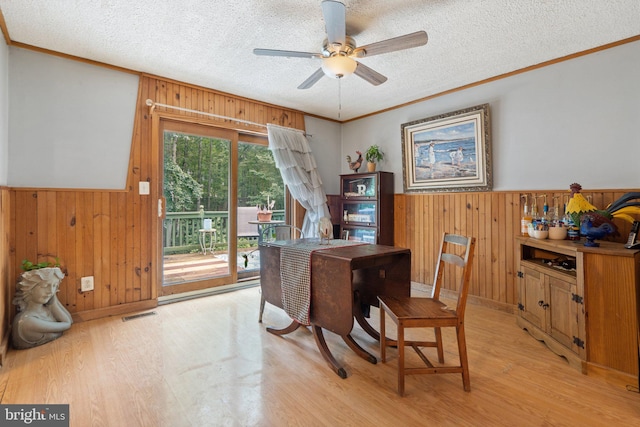590 Vaught Dr, Front Royal, VA 22630 - dining area with wood walls, wainscoting, crown molding, light wood-style flooring, and a textured ceiling