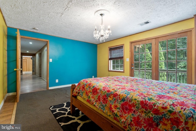 590 Vaught Dr, Front Royal, VA 22630 - carpeted bedroom with a chandelier, wood finished floors, access to exterior, and a textured ceiling