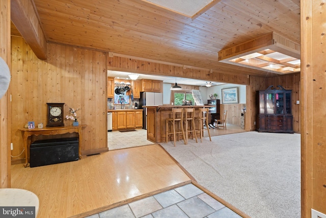 590 Vaught Dr, Front Royal, VA 22630 - kitchen with wood walls, a wood ceiling with exposed beams, freestanding refrigerator, a breakfast bar area, and open floor plan