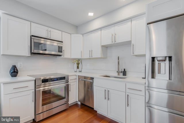 4106 Gault Pl NE Unit 3, Washington, DC 20019 - kitchen with stainless steel appliances, white cabinetry, light countertops, and light wood-style flooring