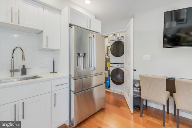 4106 Gault Pl NE Unit 3, Washington, DC 20019 - kitchen featuring stacked washer / drying machine, high end refrigerator, light wood-style floors, and white cabinets