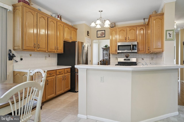 26 Fountain View Dr, Barnegat, NJ 08005 - kitchen featuring appliances with stainless steel finishes, a chandelier, tasteful backsplash, a peninsula, and ornamental molding