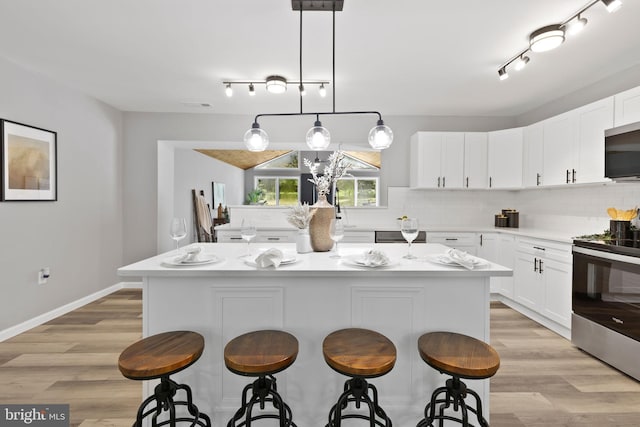 708 E Seminary, Towson, MD 21286 - kitchen with appliances with stainless steel finishes, a kitchen bar, a kitchen island, and track lighting