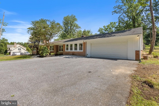 708 E Seminary, Towson, MD 21286 - view of front of home featuring asphalt driveway, brick siding, an attached garage, and a chimney