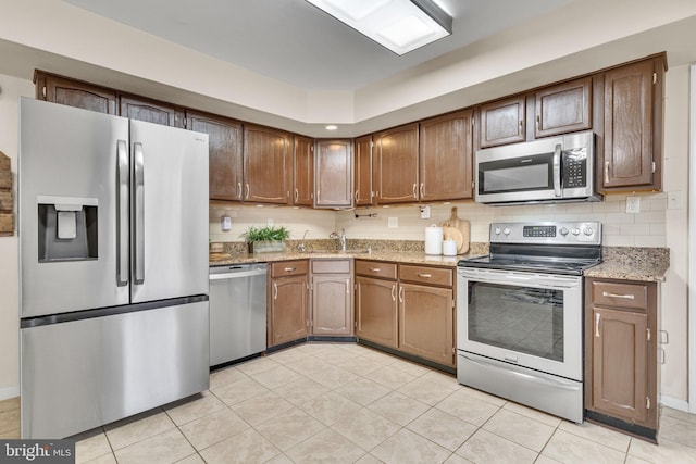 9216 Spring Acres Rd, Clinton, MD 20735 - kitchen with stainless steel appliances, light stone countertops, light tile patterned flooring, and tasteful backsplash
