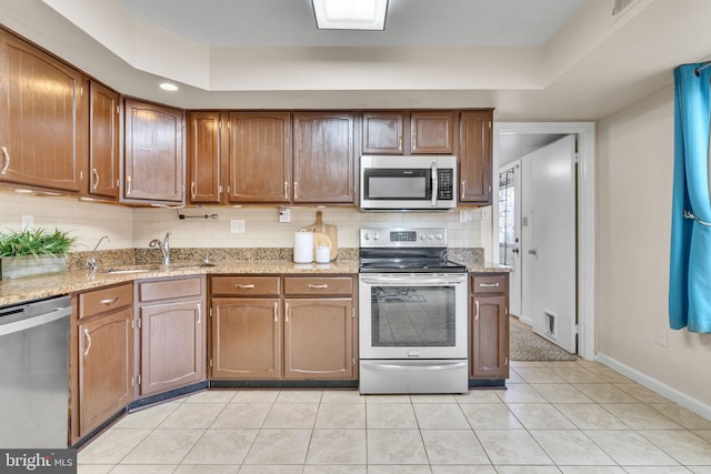 9216 Spring Acres Rd, Clinton, MD 20735 - kitchen featuring stainless steel appliances, decorative backsplash, light tile patterned floors, and light stone counters