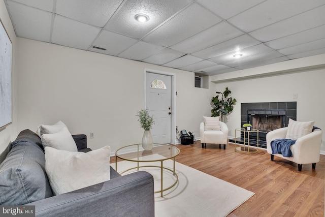 9216 Spring Acres Rd, Clinton, MD 20735 - living room featuring wood finished floors, a tiled fireplace, and a drop ceiling