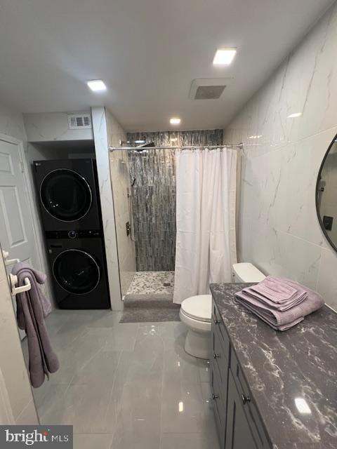 12163 Penderview Ter Unit 1034, Fairfax, VA 22033 - full bathroom featuring estacked washer and dryer, a tile shower, marble finish floors, and vanity