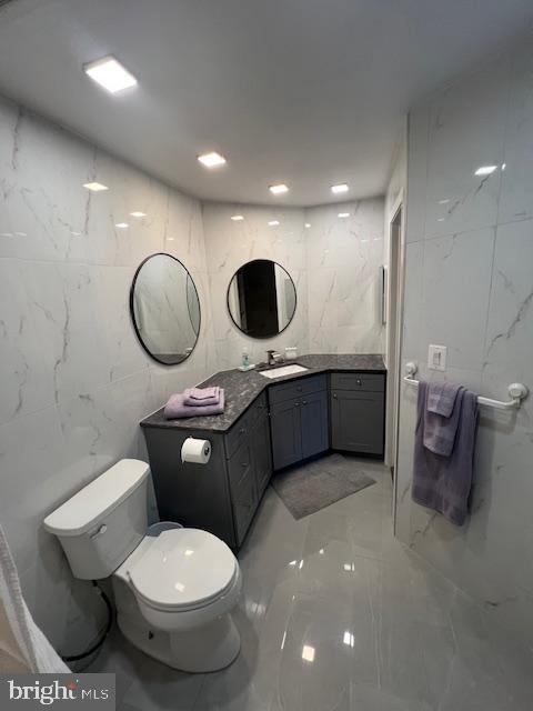 12163 Penderview Ter Unit 1034, Fairfax, VA 22033 - bathroom with marble tiled floors, vanity, and tile walls