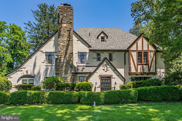 722 River Rd, Ewing, NJ 08628 - tudor home with stucco siding, a chimney, a front lawn, and roof with shingles