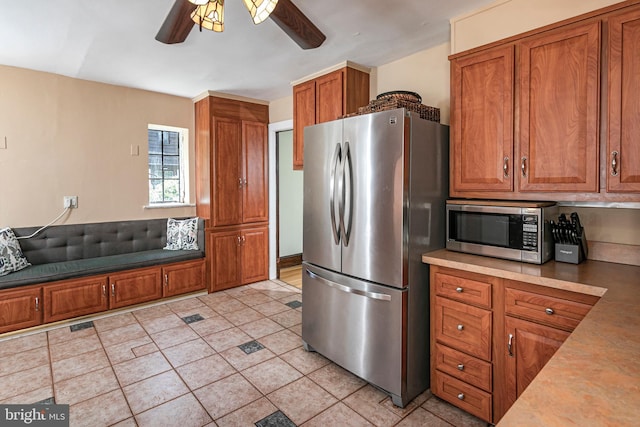 722 River Rd, Ewing, NJ 08628 - kitchen featuring appliances with stainless steel finishes, brown cabinets, ceiling fan, and light tile patterned floors