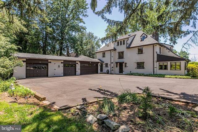 722 River Rd, Ewing, NJ 08628 - view of home's exterior with a chimney, stucco siding, and asphalt driveway