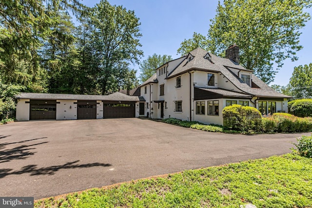 722 River Rd, Ewing, NJ 08628 - view of front of home with a chimney, asphalt driveway, stucco siding, and an attached garage