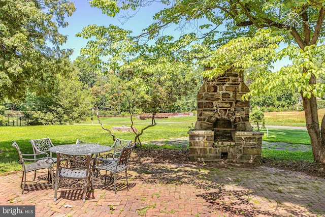 722 River Rd, Ewing, NJ 08628 - view of grassy yard featuring an outdoor stone fireplace, a patio area, outdoor dining area, and view of wooded area