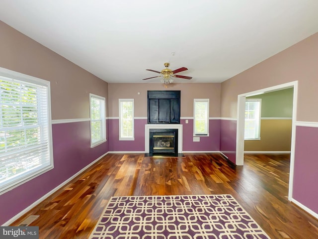 7403 Hawthorne St, Landover, MD 20785 - unfurnished living room with plenty of natural light, wood finished floors, a ceiling fan, and a fireplace with flush hearth