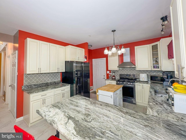 7403 Hawthorne St, Landover, MD 20785 - kitchen with stainless steel appliances, wall chimney exhaust hood, light marble finish floors, backsplash, and light stone counters