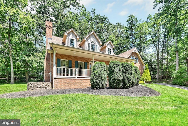 59 Segovia Ct, Hanover, PA 17331 - view of front facade featuring a porch, a front lawn, brick siding, and a chimney