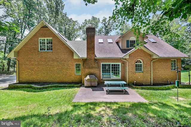 59 Segovia Ct, Hanover, PA 17331 - rear view of property featuring a chimney, a lawn, a patio area, brick siding, and a shingled roof