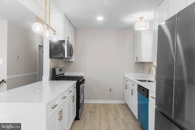 1614 Maryland Ave, Woodbridge, VA 22191 - kitchen featuring stainless steel appliances, light wood finished floors, white cabinets, a peninsula, and decorative light fixtures